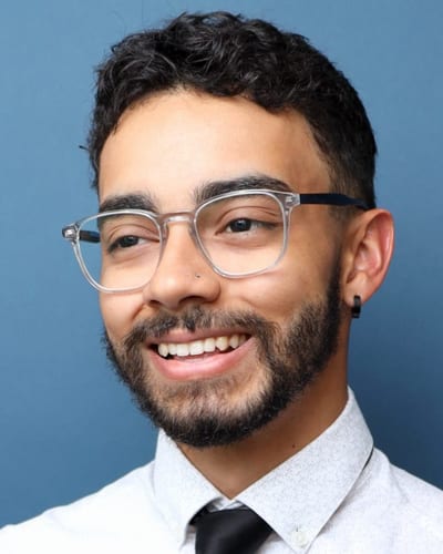 Reece Geofroy, smiling, in glasses and a light shirt.